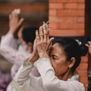 a woman in a white dress holding her hands up