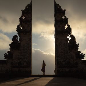 woman wearing beige dress in the middle of arch temple